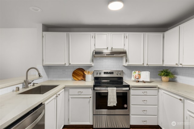 kitchen featuring appliances with stainless steel finishes, sink, white cabinets, backsplash, and light stone counters