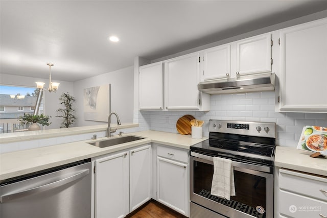 kitchen with white cabinetry, stainless steel appliances, decorative light fixtures, and sink