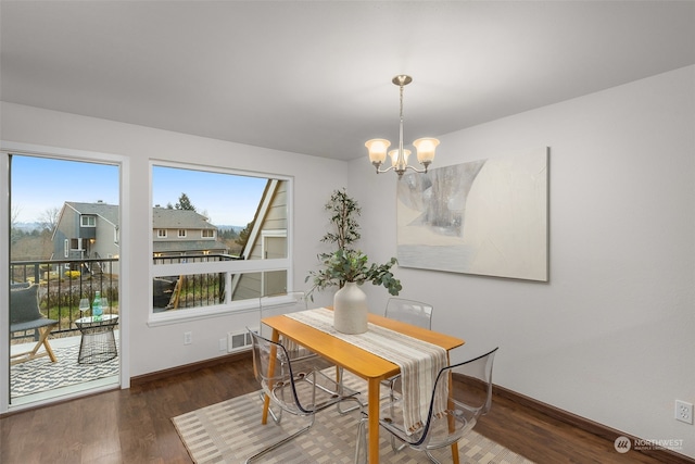 dining room featuring dark wood-type flooring and a chandelier