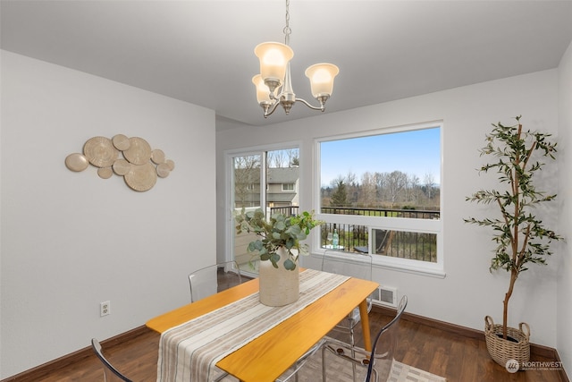 dining room with a notable chandelier and dark hardwood / wood-style flooring