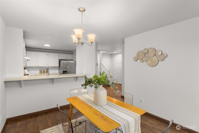 dining space with an inviting chandelier, dark hardwood / wood-style flooring, and sink