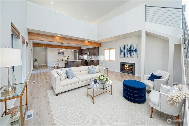 living room featuring light hardwood / wood-style flooring and a high ceiling