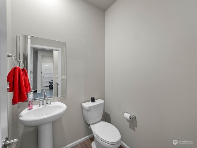 bathroom with hardwood / wood-style flooring and toilet