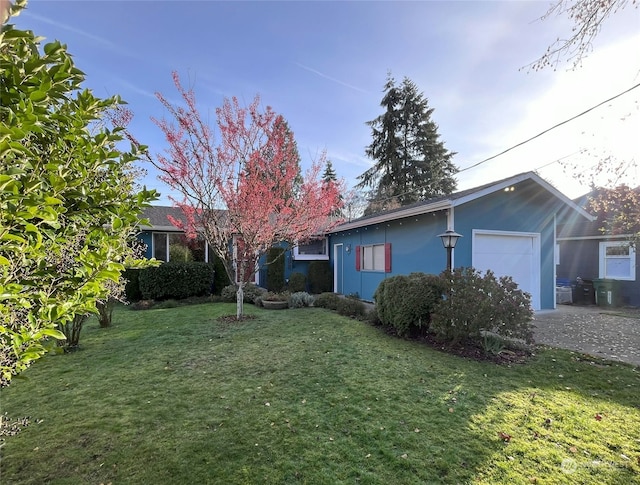 single story home featuring a garage and a front lawn