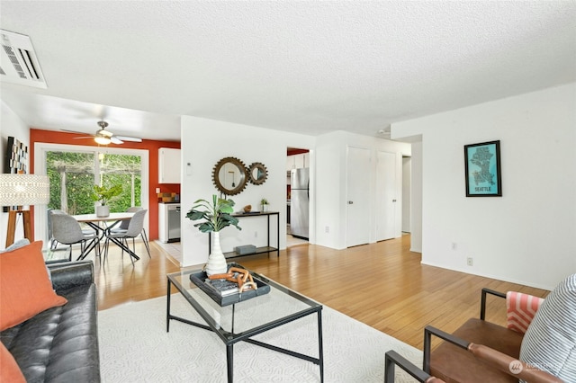 living room featuring a textured ceiling and light hardwood / wood-style floors