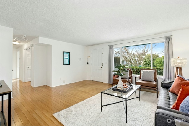 living room with light hardwood / wood-style floors and a textured ceiling