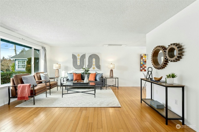 living room featuring a textured ceiling and light hardwood / wood-style flooring