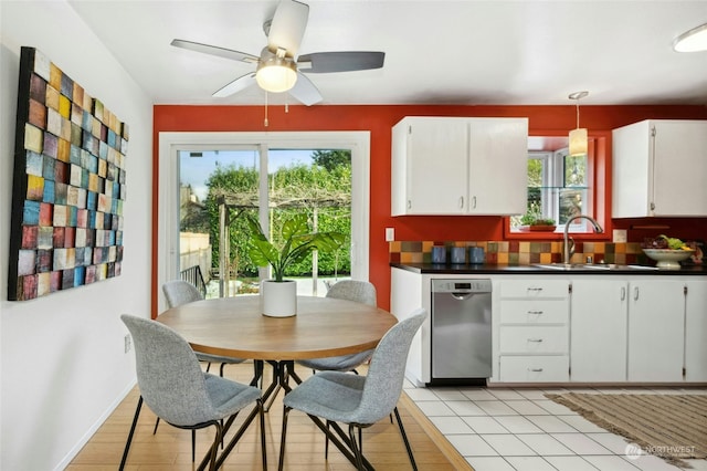 kitchen with white cabinetry, hanging light fixtures, plenty of natural light, and dishwasher