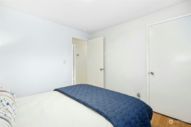 bedroom with wood-type flooring and a textured ceiling