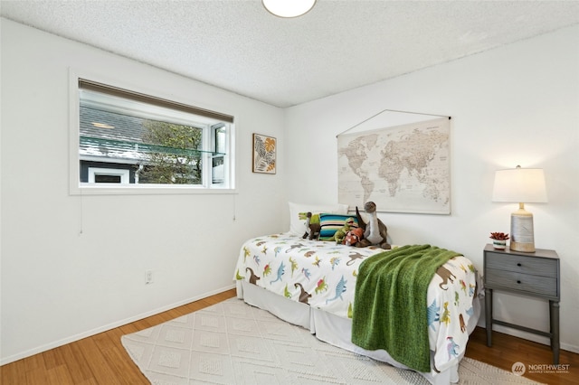 bedroom featuring a textured ceiling and light wood-type flooring