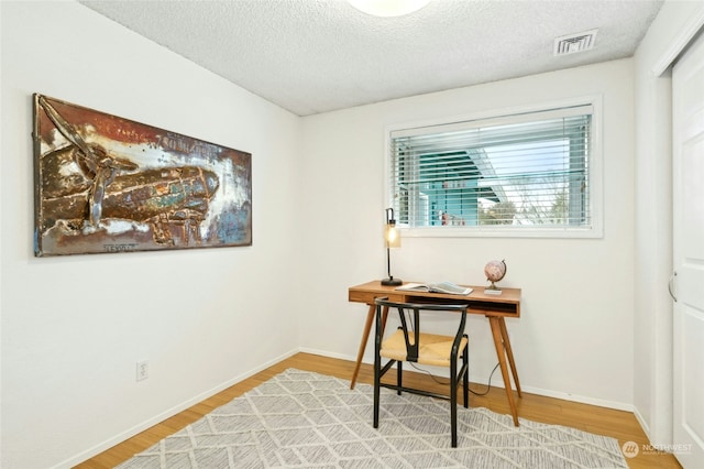 home office with hardwood / wood-style flooring and a textured ceiling