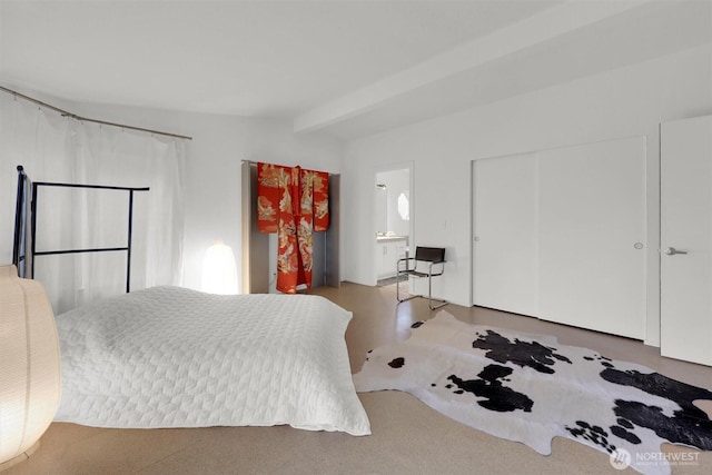 bedroom featuring vaulted ceiling with beams, a closet, and ensuite bathroom