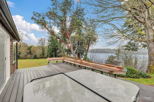 deck featuring a water view and a lawn