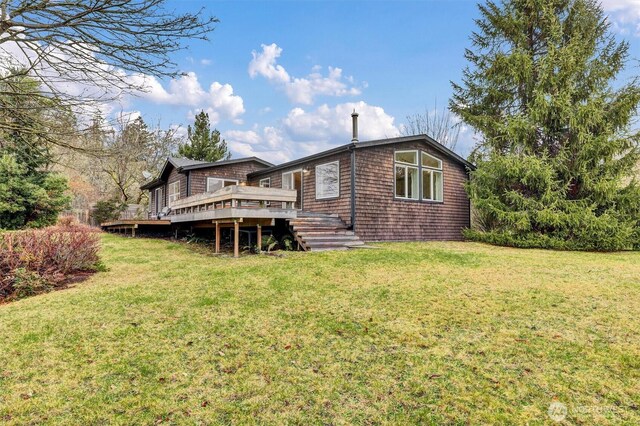 back of house featuring a wooden deck and a yard