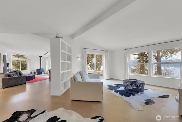 living area featuring lofted ceiling with beams and a wood stove