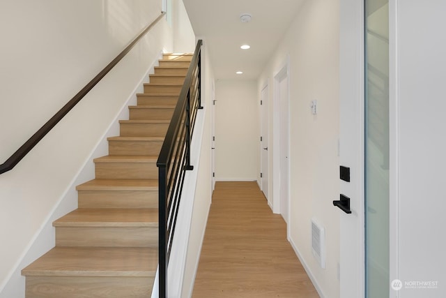 stairs with hardwood / wood-style flooring