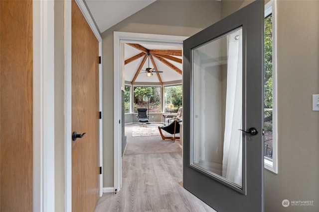 doorway featuring light hardwood / wood-style flooring and vaulted ceiling