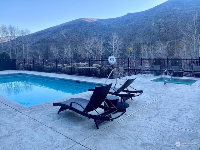 view of pool featuring a mountain view and a patio area