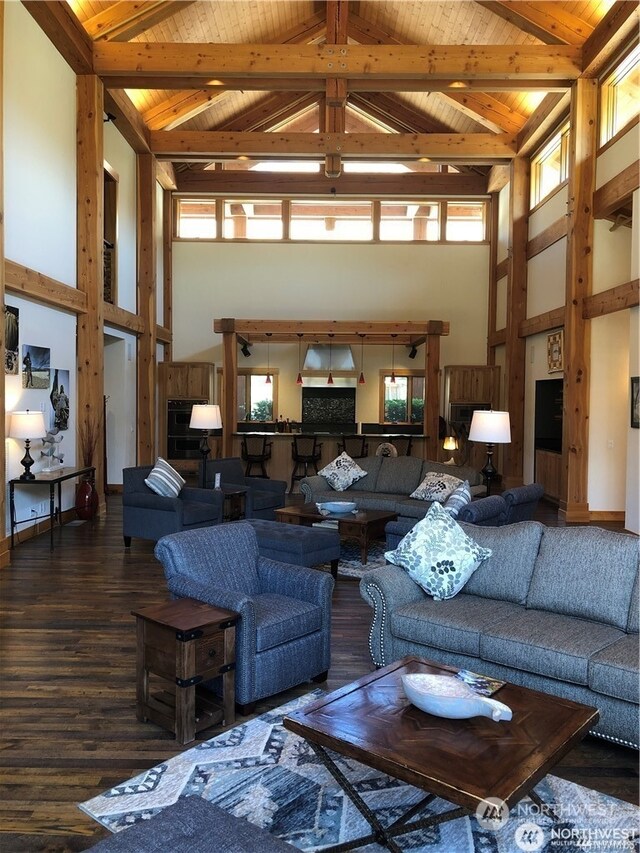 living room with wood ceiling, plenty of natural light, and beamed ceiling