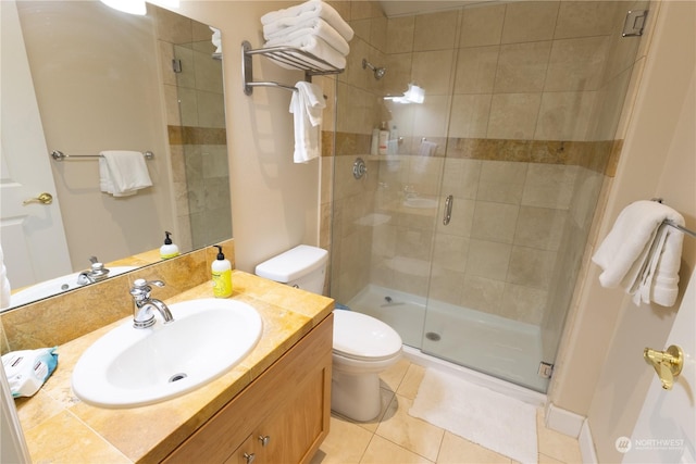 bathroom with vanity, toilet, tile patterned flooring, and a shower with door