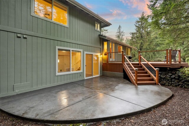 back of property with a patio area, a wooden deck, and stairs