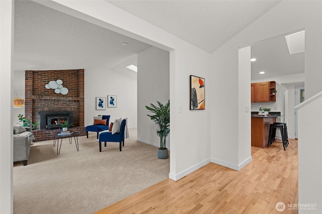 interior space featuring baseboards, lofted ceiling, a textured ceiling, light wood-style floors, and recessed lighting