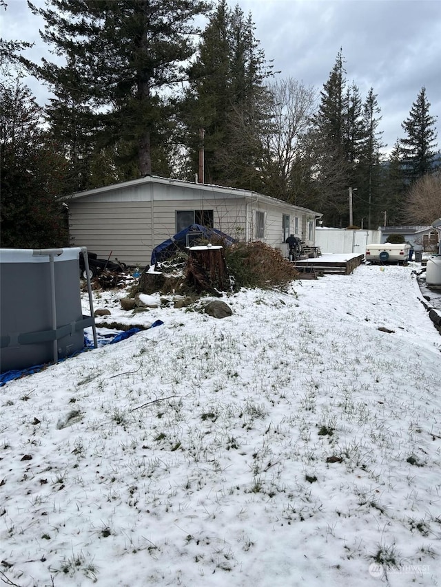 yard layered in snow featuring a deck