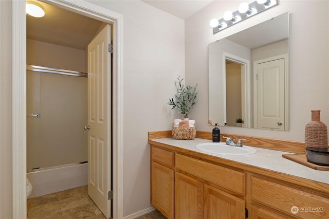 full bathroom with vanity, bath / shower combo with glass door, and toilet