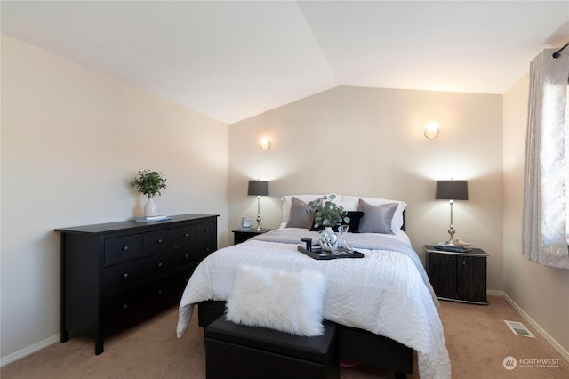 bedroom with vaulted ceiling and light colored carpet