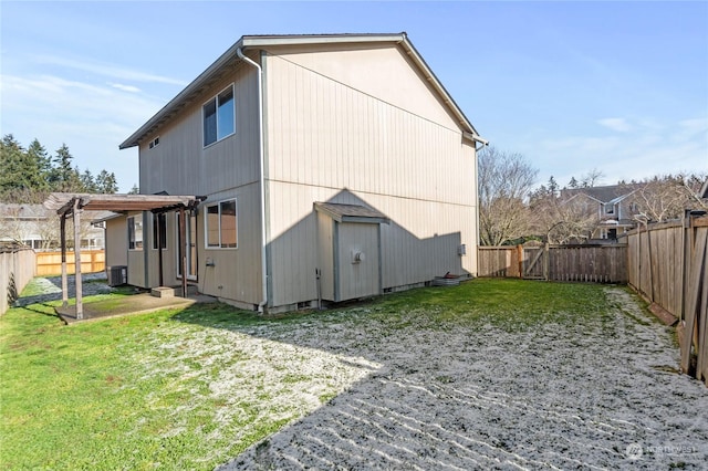 back of property with a yard, a pergola, and central AC unit