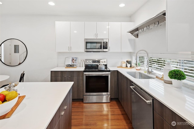 kitchen featuring dark brown cabinetry, appliances with stainless steel finishes, sink, and white cabinets