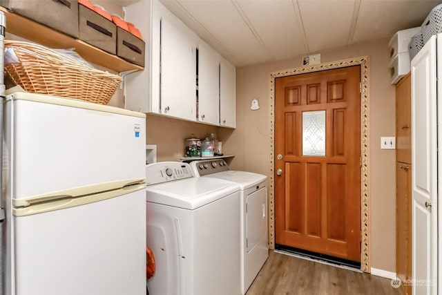 clothes washing area with independent washer and dryer, cabinets, and light hardwood / wood-style flooring