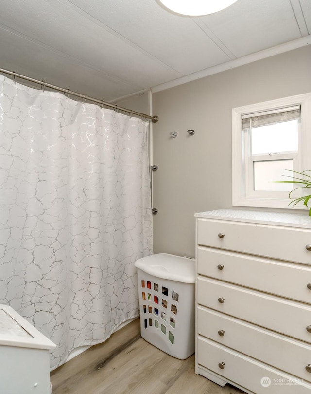 bathroom with wood-type flooring, ornamental molding, and a shower with curtain