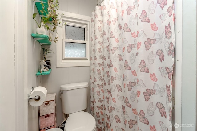 bathroom with a shower with curtain and toilet