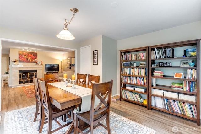 dining area featuring a fireplace and light wood-type flooring