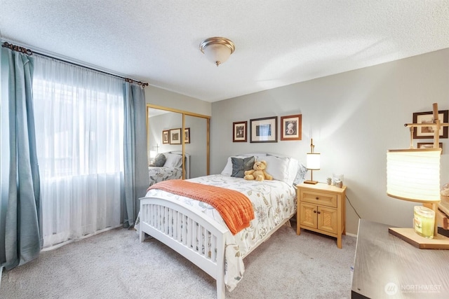 bedroom featuring a closet, light colored carpet, and a textured ceiling