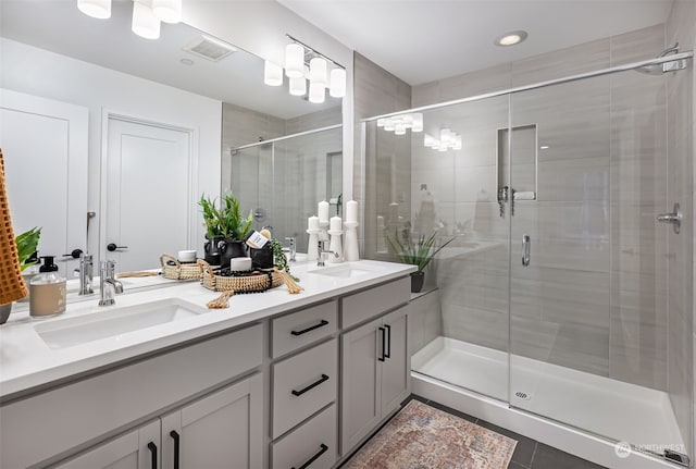 bathroom featuring vanity, a shower with shower door, and tile patterned flooring