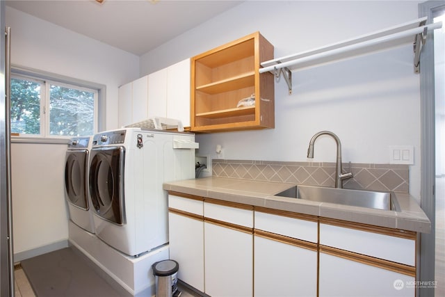 laundry area with cabinets, independent washer and dryer, and sink