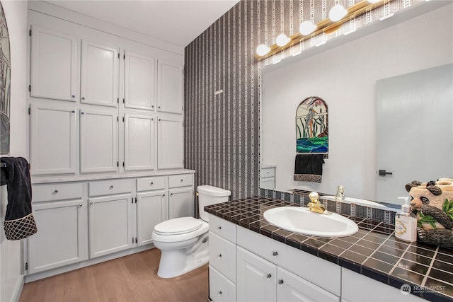 bathroom with vanity, hardwood / wood-style flooring, and toilet