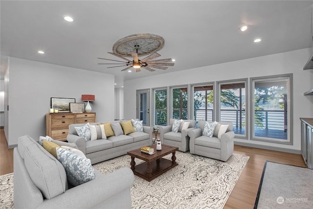 living room with a wealth of natural light, ceiling fan, and light wood-type flooring