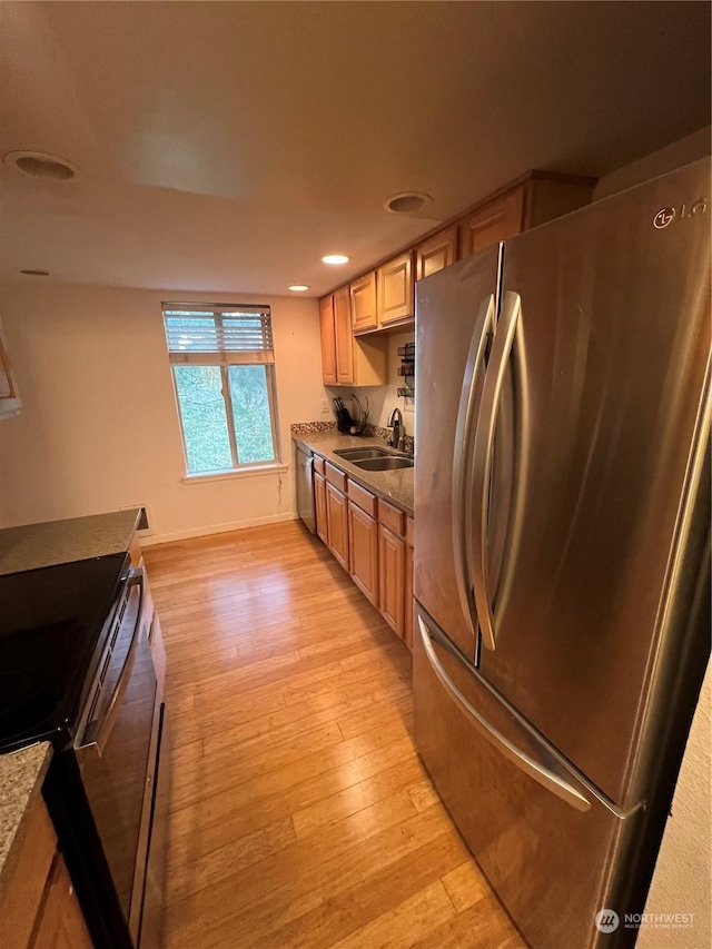 kitchen with sink, light brown cabinets, stainless steel appliances, and light wood-type flooring