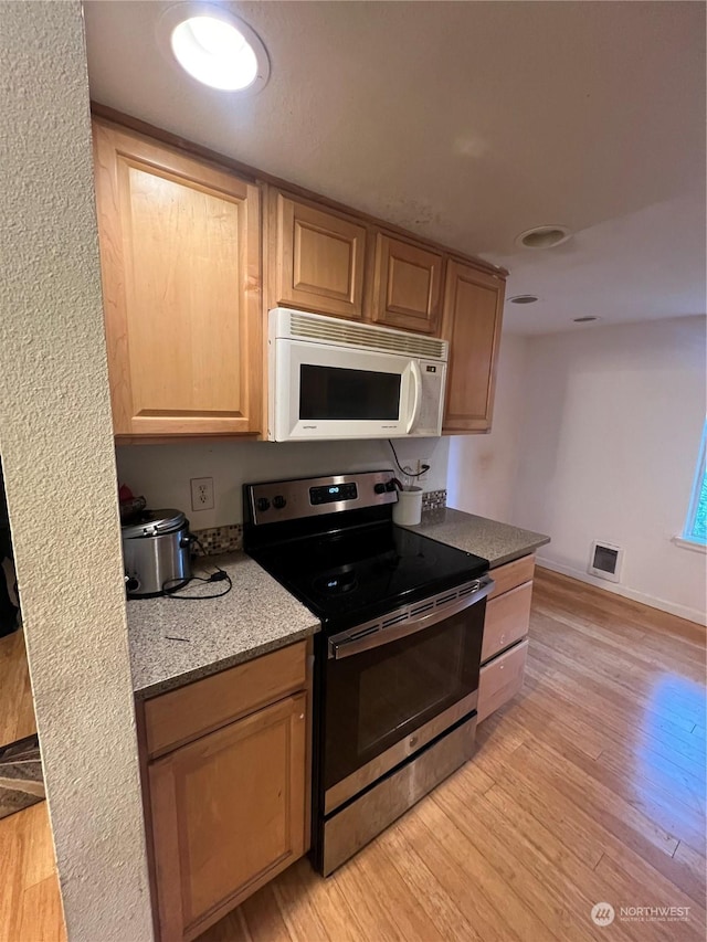 kitchen with light brown cabinets, stainless steel range with electric cooktop, and light wood-type flooring