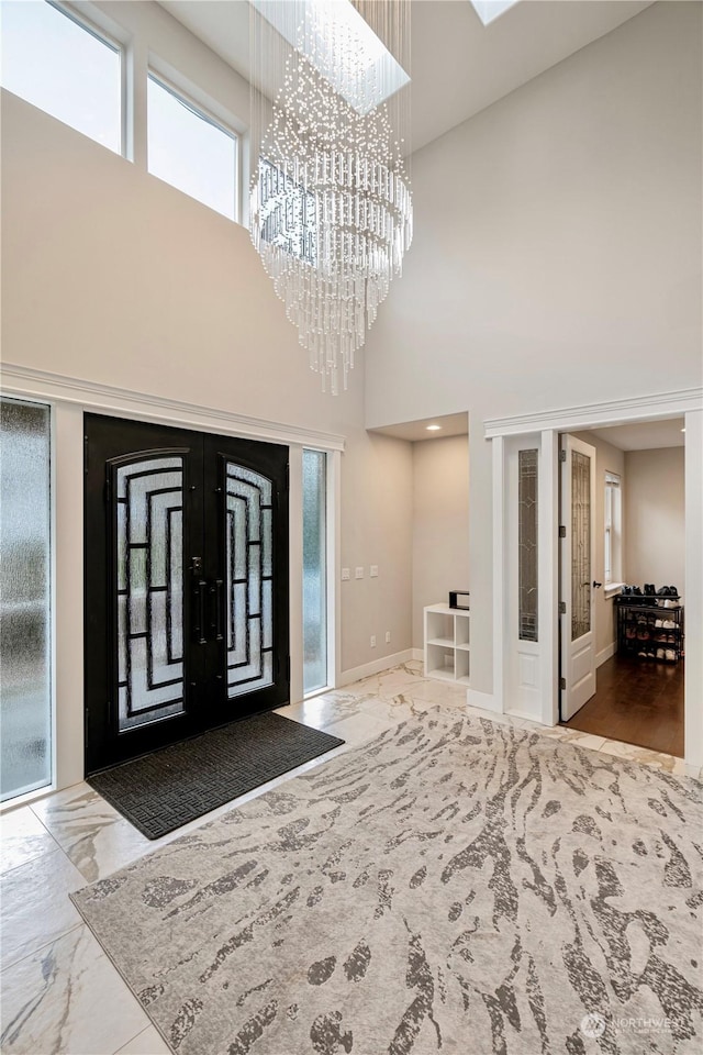 foyer entrance featuring a chandelier and french doors