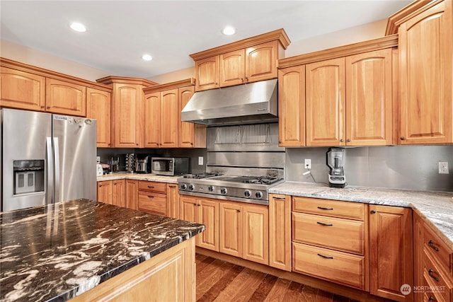 kitchen with dark wood-type flooring, appliances with stainless steel finishes, tasteful backsplash, and dark stone countertops