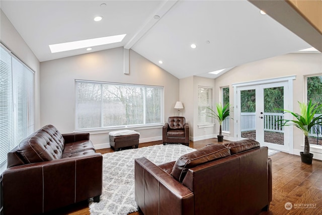 living room with lofted ceiling with skylight, dark wood-type flooring, a wealth of natural light, and french doors