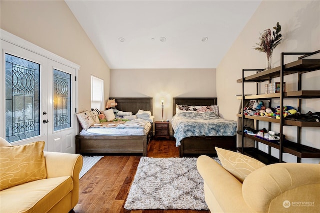 bedroom with lofted ceiling, hardwood / wood-style flooring, multiple windows, and french doors