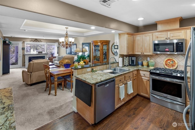 kitchen featuring sink, appliances with stainless steel finishes, backsplash, a raised ceiling, and kitchen peninsula