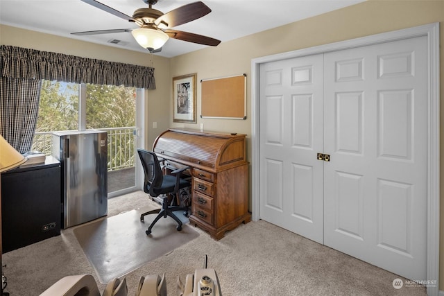 carpeted home office featuring ceiling fan