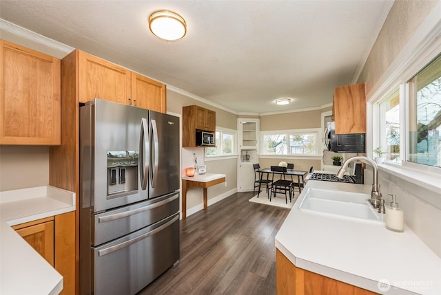 kitchen with a sink, stainless steel appliances, plenty of natural light, and ornamental molding