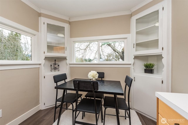 dining space featuring dark wood finished floors, a healthy amount of sunlight, crown molding, and baseboards